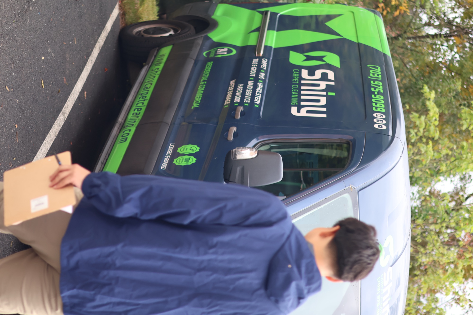 Shiny team member beside a branded cleaning van